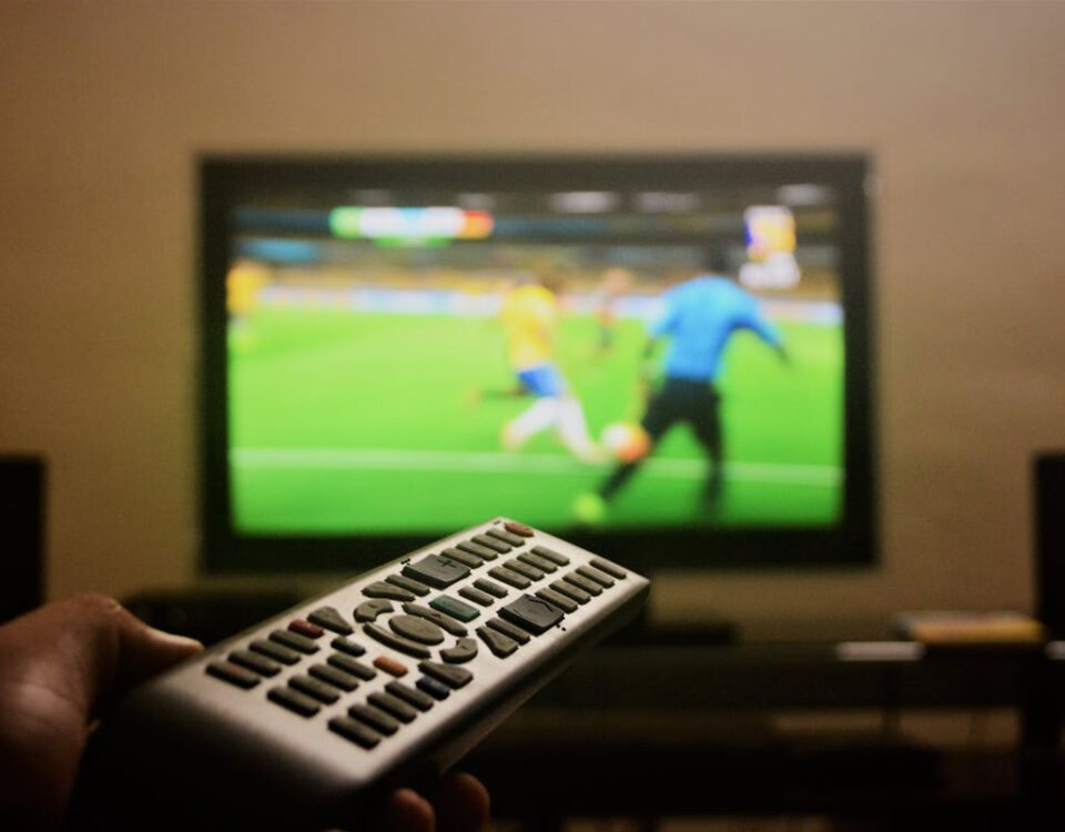 Como Melhorar a Qualidade de Streaming em Casa? Photo of a Person's Hand Holding a Remote Control