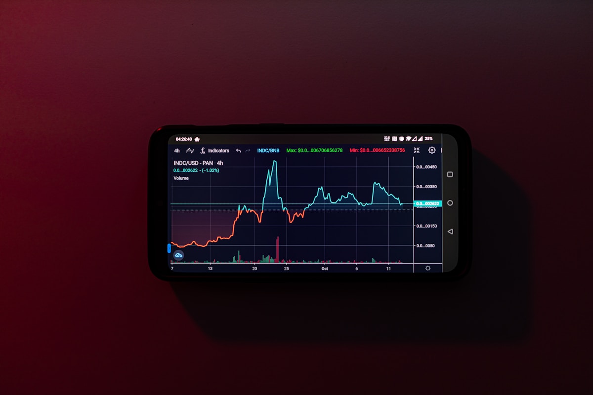 Como Investir em Criptomoedas Usando Seu Smartphone a cell phone displaying a stock chart on a red background