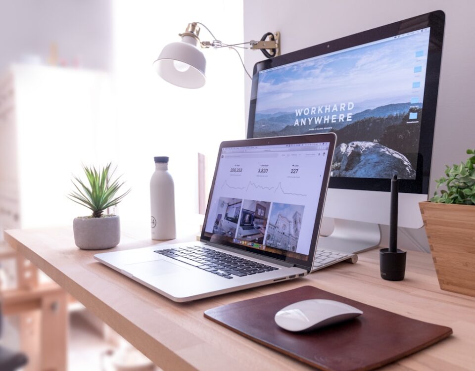 Plataformas gratuitas para criar sites empresariais MacBook Pro on table beside white iMac and Magic Mouse