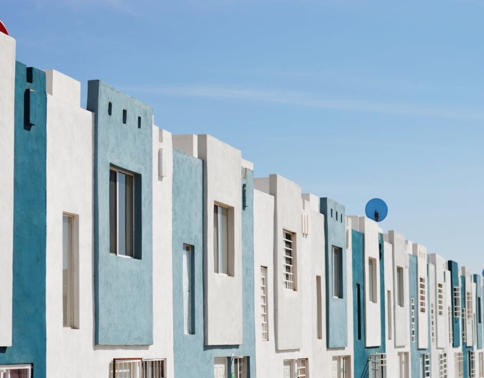 Geometric blue and white facade of a modern apartment building under a clear sky.