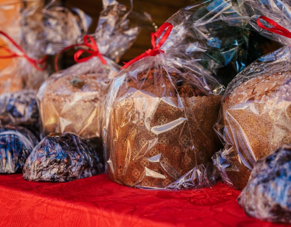 Como a tecnologia ajuda as confeitarias a vender mais panetones na época do Natal? a table topped with bags of cookies and muffins