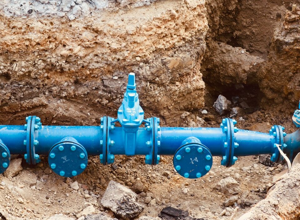 Ferramentas tecnológicas para inspeção de encanamentos a blue pipe laying on top of a pile of dirt