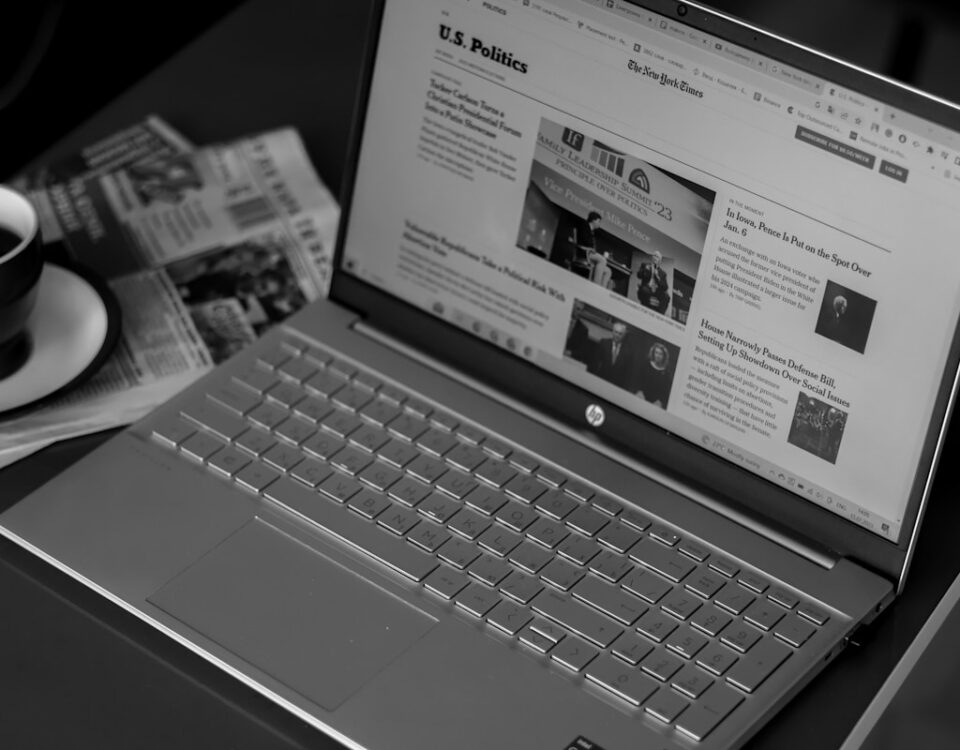 Como a IA escolhe notícias populares a laptop computer sitting on top of a desk next to a cup of coffee