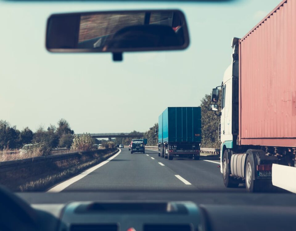 O papel da tecnologia na eficiência de grandes redes logísticas View through rearview mirror of trucks on a German highway, driving towards Bamberg.
