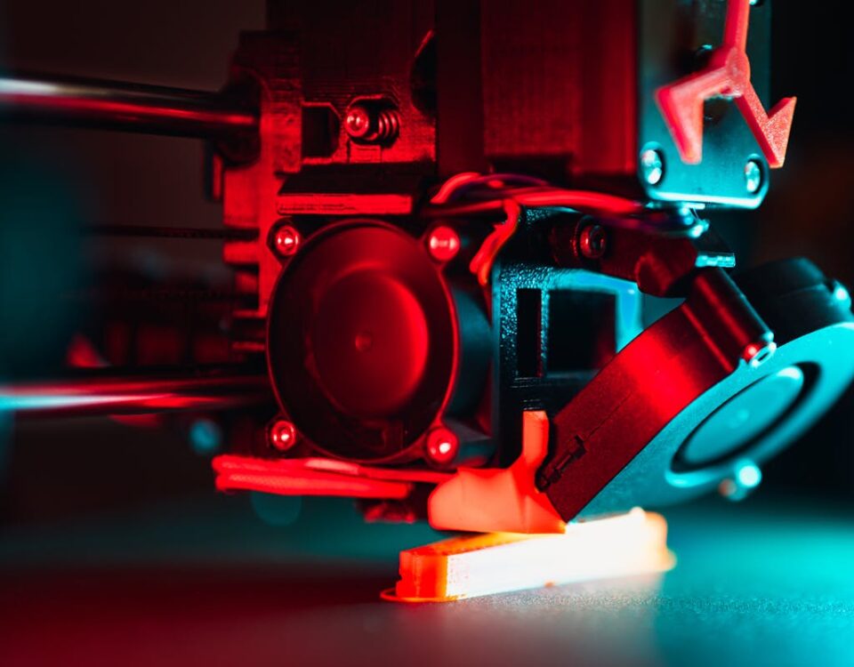 Impressão 3D revolucionando souvenires turísticos Vibrant close-up of a 3D printer creating a prototype with red and blue lights.