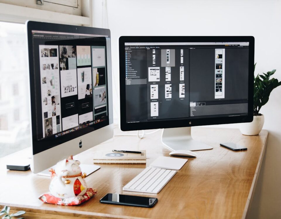 Tecnologias que aumentam a interatividade em sites A well-organized design workspace with dual monitors and design software on display.
