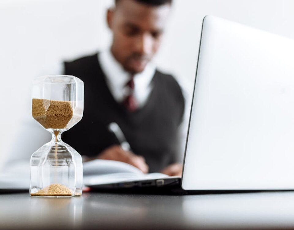 Ferramentas digitais que todo advogado criminalista deve conhecer Businessman at desk with hourglass indicating time management and daily work routine.