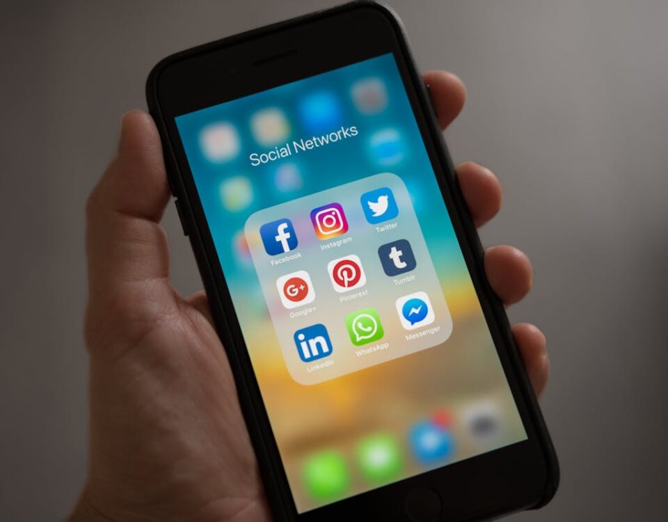 Como escolher o melhor painel SMM para sua estratégia A smartphone displaying various social media icons held in a hand, showcasing modern communication apps.
