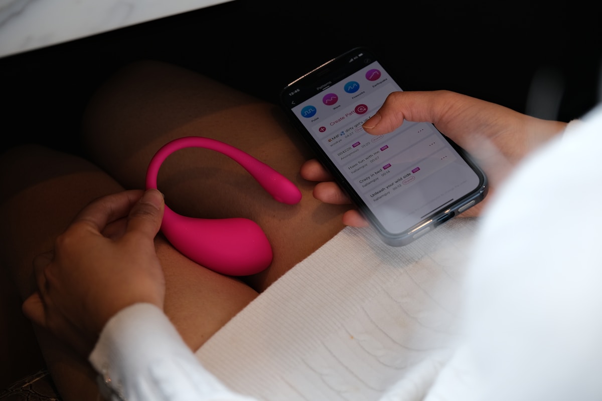 Gadgets inovadores que dominam os sex shops a person holding a cell phone with a pink handle