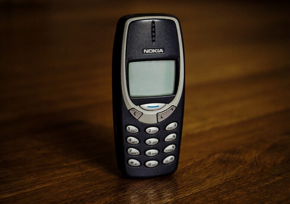 Celular Nokia antigo com teclado físico sobre superfície de madeira