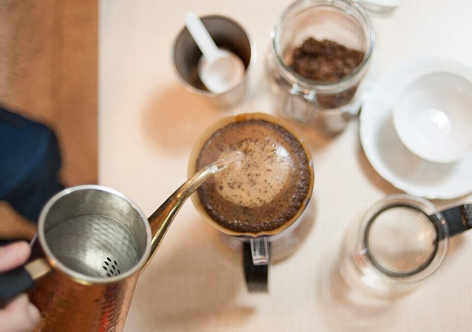 Água sendo despejada em coador de café com chaleira de bico fino