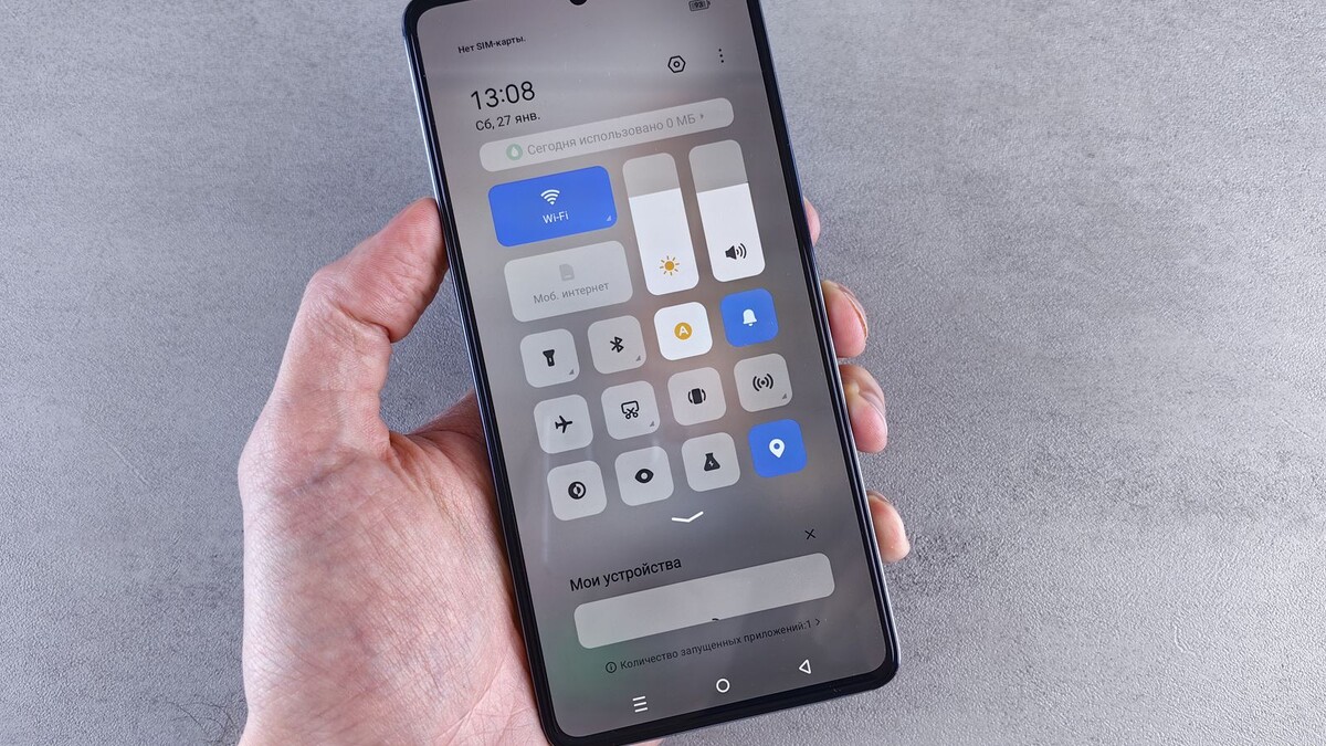 Mão segurando um celular Android com o painel rápido aberto e o Wi-Fi ativado
