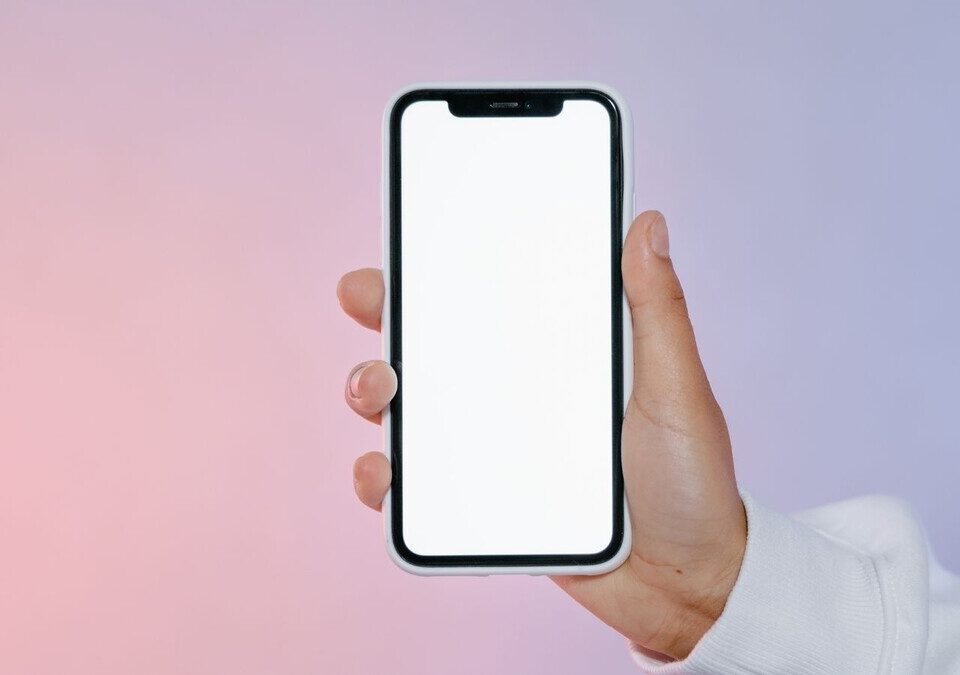 Mão segurando um smartphone com a tela em branco