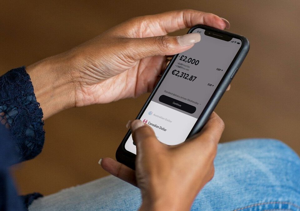 Pessoa segurando um celular com aplicativo financeiro aberto