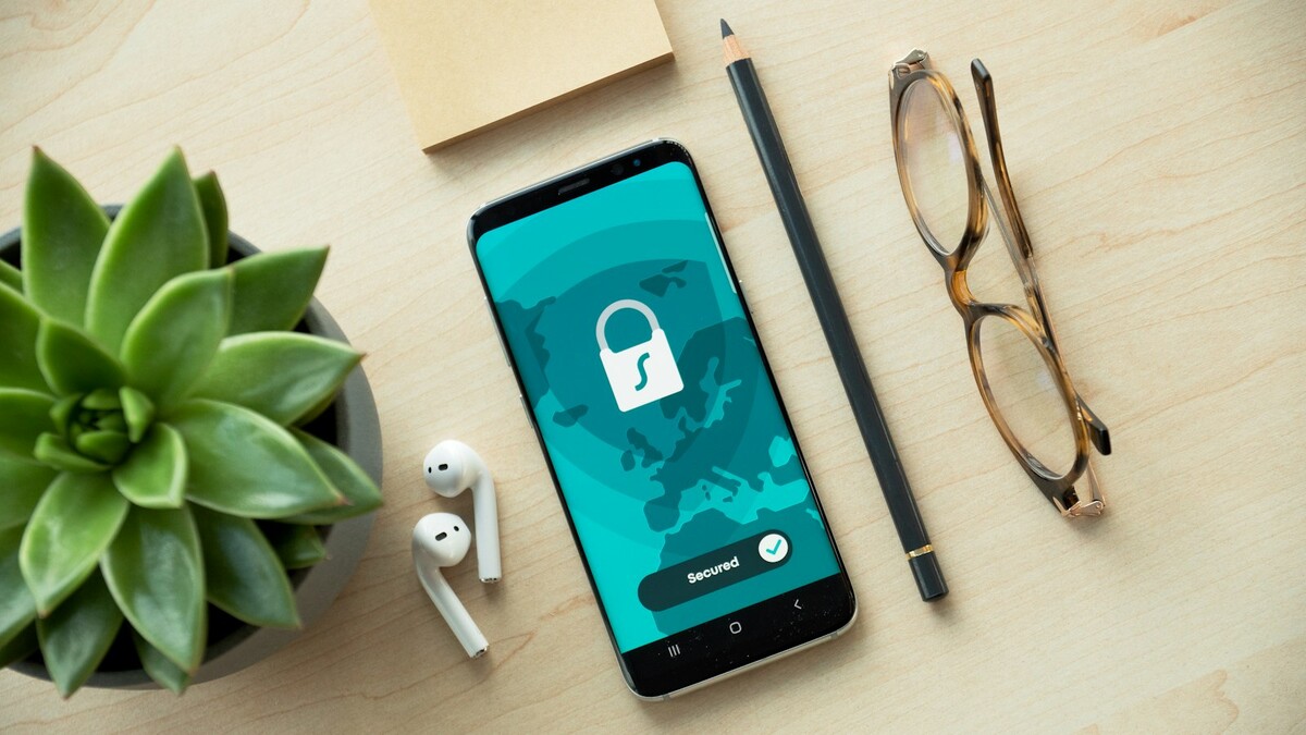 Falha no Microsoft Authenticator: como atualizar e checar a versão Celular com ícone de cadeado na tela sobre uma mesa de madeira