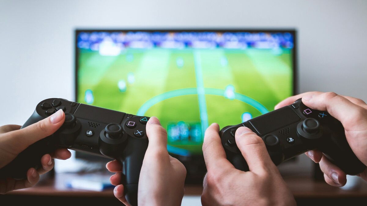 Marco legal dos games regulamentado: o que muda para jogadores e pais Duas pessoas jogando videogame com controles de console
